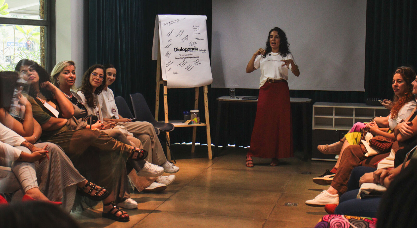 Apresentação no Dialogando, com o cartaz do evento ao fundo